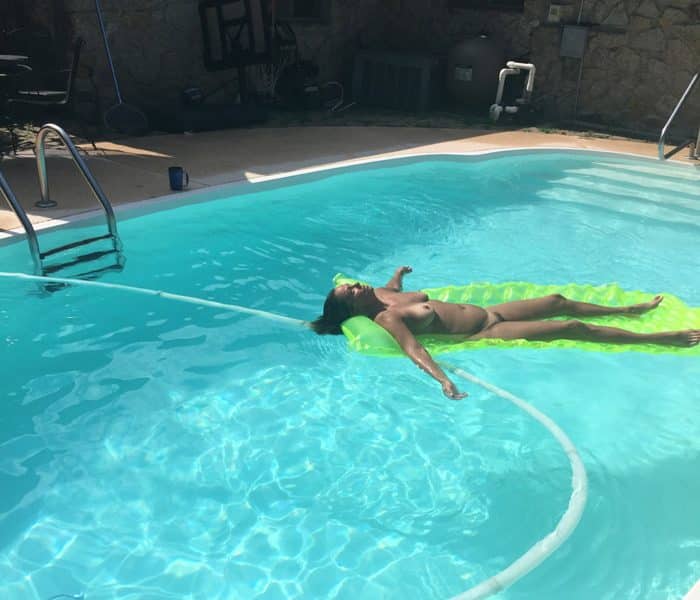 Nathalie, femme poilue bronze nue dans sa piscine